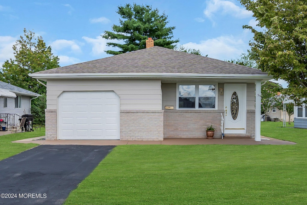 view of front of house featuring a garage and a front lawn