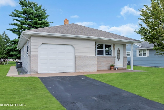 ranch-style home featuring a garage, a front yard, and central air condition unit