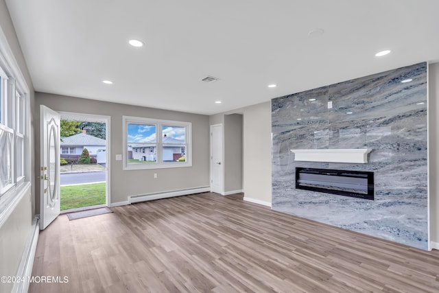 unfurnished living room featuring light hardwood / wood-style floors and baseboard heating