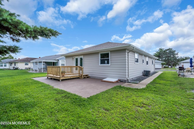 rear view of property featuring a wooden deck, a yard, central AC unit, and a patio