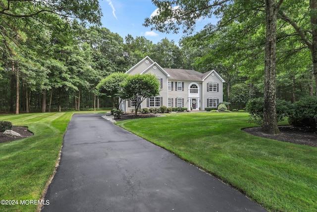 colonial home with a front lawn