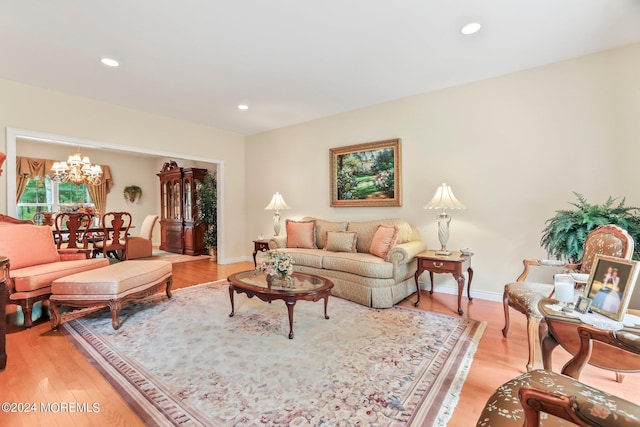 living area with recessed lighting, baseboards, a notable chandelier, and light wood finished floors