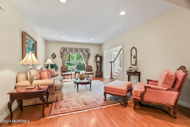 living area with stairs, recessed lighting, baseboards, and wood finished floors