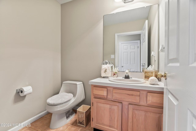 half bathroom with vanity, toilet, and tile patterned floors