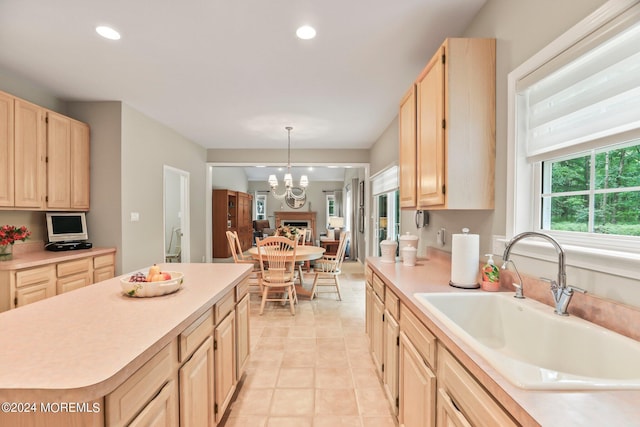 kitchen with recessed lighting, light countertops, a sink, and light brown cabinetry