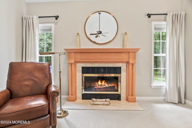 sitting room featuring carpet flooring, a tile fireplace, a wealth of natural light, and baseboards