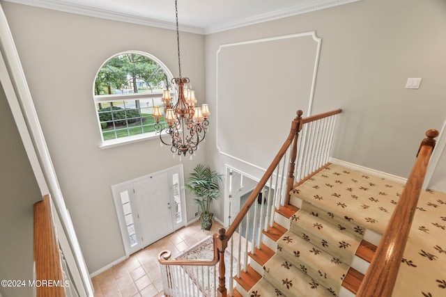 foyer entrance featuring light tile patterned flooring, baseboards, stairs, ornamental molding, and an inviting chandelier