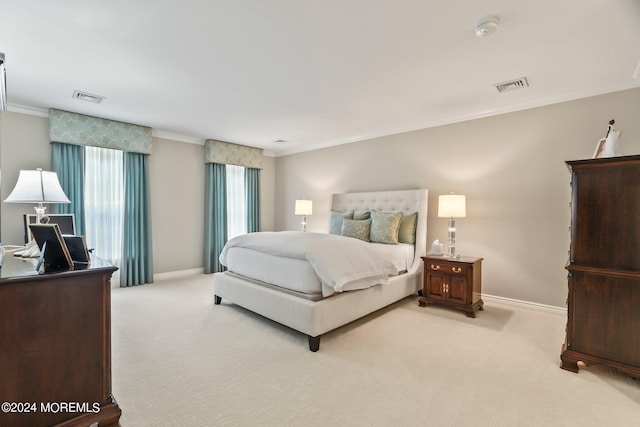 bedroom with baseboards, visible vents, and light colored carpet