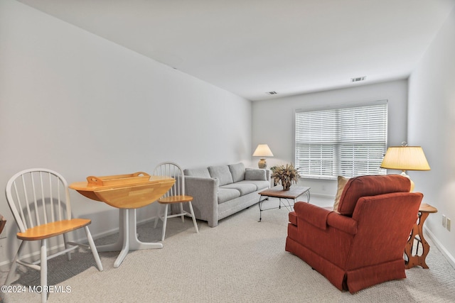 carpeted living area featuring visible vents and baseboards