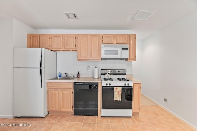 kitchen with white appliances, visible vents, light countertops, and light brown cabinetry