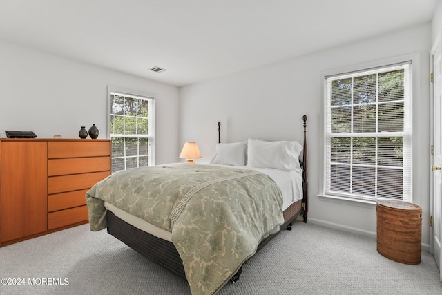 bedroom featuring light colored carpet, visible vents, and baseboards