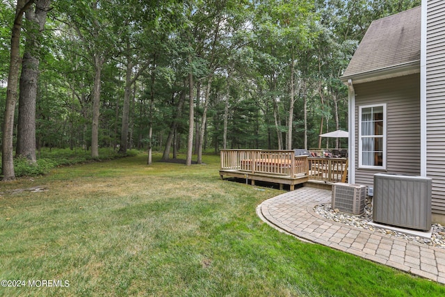 view of yard featuring central air condition unit and a wooden deck