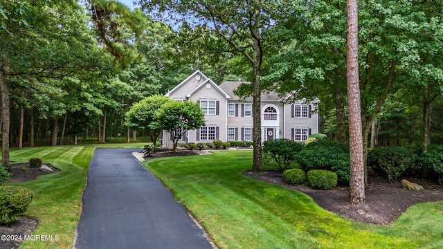 colonial-style house with a front lawn and aphalt driveway