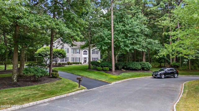 colonial home featuring a front lawn