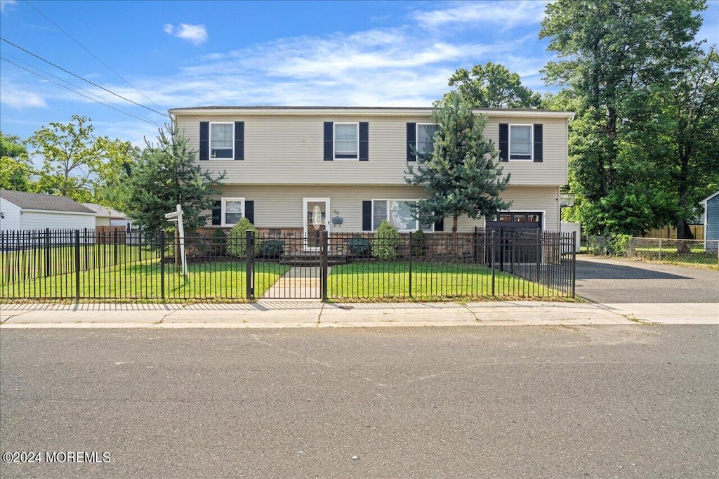 view of front of property featuring a garage and a front lawn