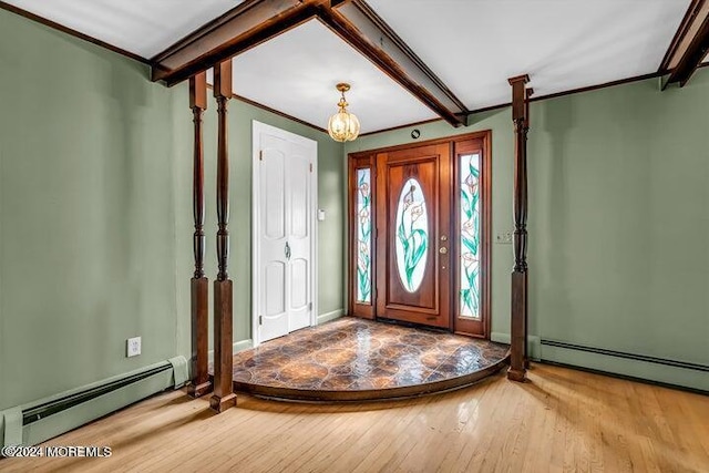 foyer with hardwood / wood-style flooring, ornamental molding, and a baseboard heating unit