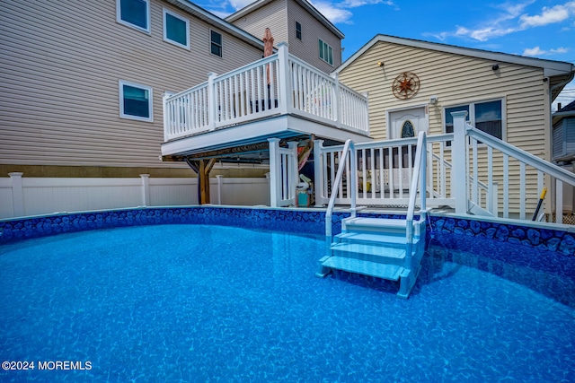 view of swimming pool featuring a deck, fence, and a fenced in pool