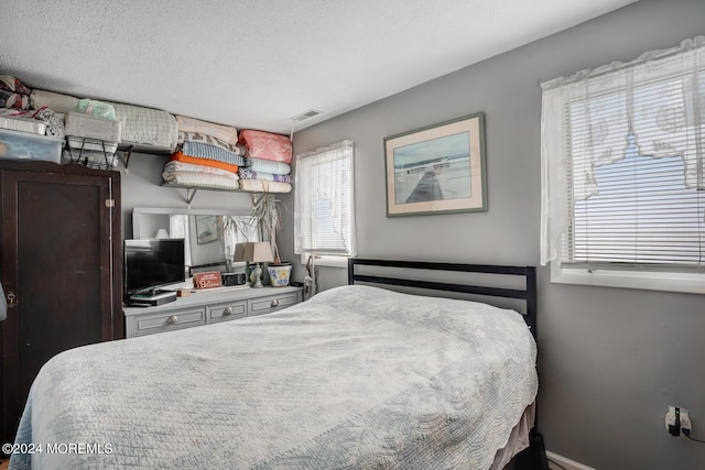 bedroom featuring a textured ceiling and visible vents