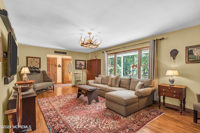 living room featuring a chandelier and light wood-type flooring