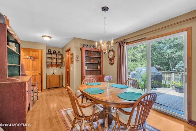 dining room with light hardwood / wood-style flooring and a notable chandelier