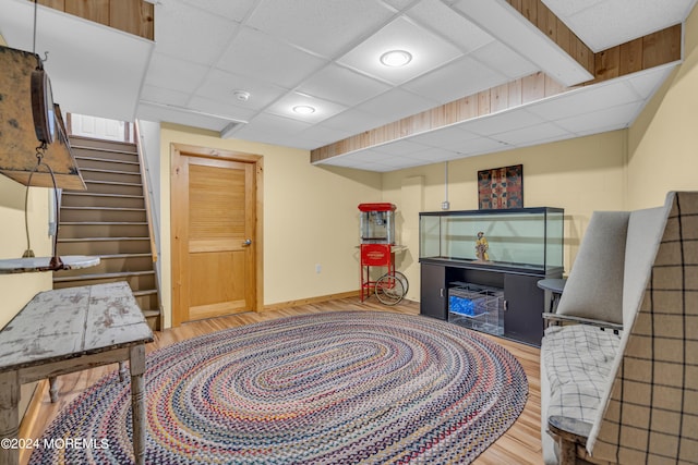 sitting room featuring a drop ceiling and wood-type flooring