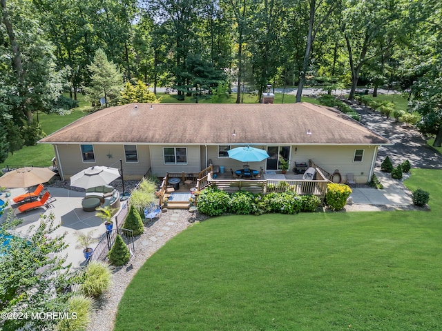 rear view of house featuring a wooden deck and a yard