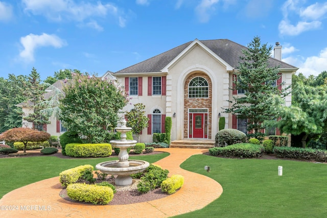 colonial inspired home with a front lawn