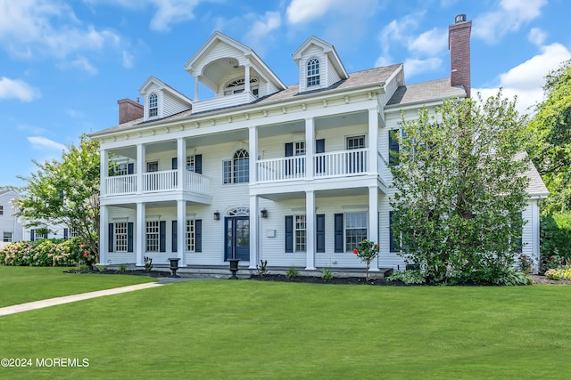 view of front of home featuring a balcony and a front lawn