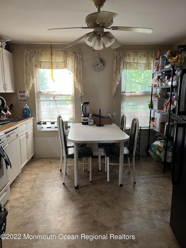 dining area with ceiling fan and sink