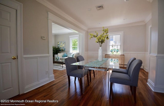 dining space with crown molding, dark hardwood / wood-style floors, and a baseboard heating unit