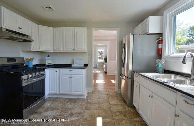 kitchen featuring sink, stainless steel appliances, white cabinetry, and a healthy amount of sunlight