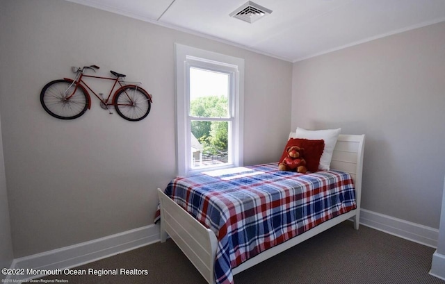 bedroom with dark carpet and crown molding