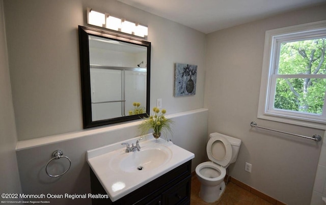 bathroom featuring vanity, toilet, and walk in shower