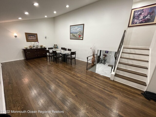 dining space with wood-type flooring and high vaulted ceiling