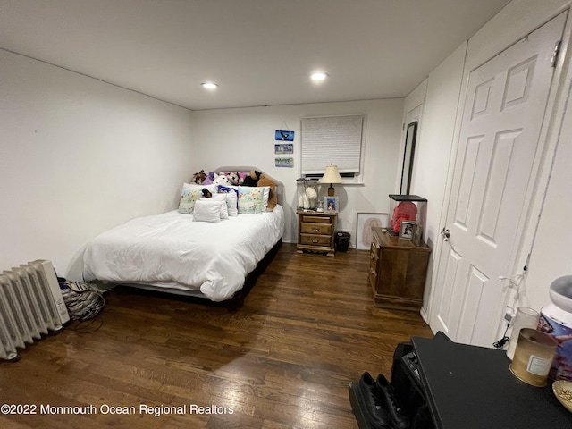 bedroom with radiator and dark hardwood / wood-style flooring