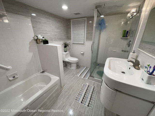 full bathroom with toilet, tile walls, independent shower and bath, tile patterned floors, and vanity