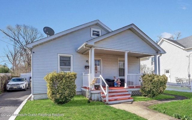 bungalow-style home with covered porch and a front lawn