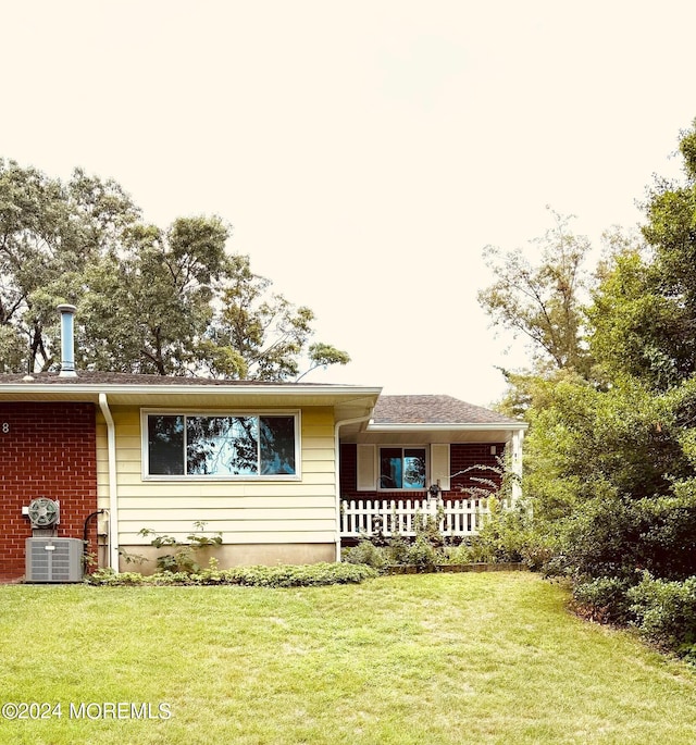 view of front facade with cooling unit and a front yard