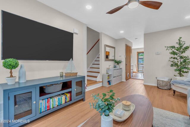 living room featuring ceiling fan and light hardwood / wood-style floors