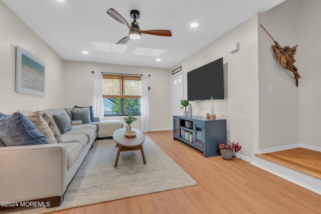 living room with light hardwood / wood-style flooring and ceiling fan