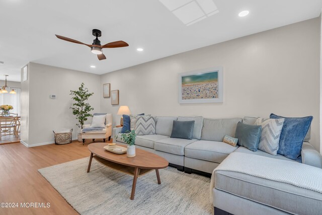 living room with light hardwood / wood-style floors and ceiling fan