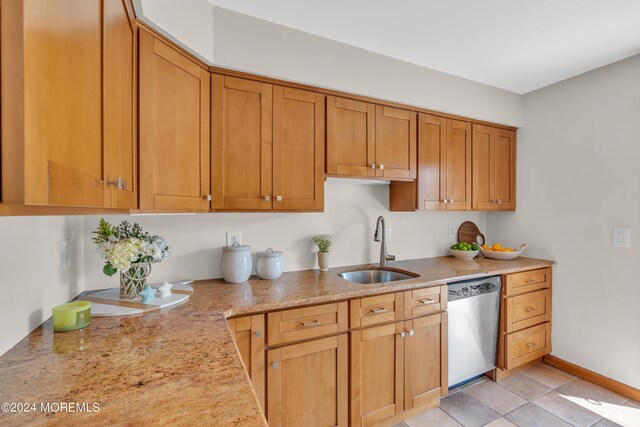 kitchen featuring sink, dishwasher, light stone counters, and light tile patterned floors