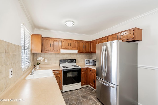 kitchen with dark tile patterned flooring, sink, white electric stove, ornamental molding, and stainless steel refrigerator