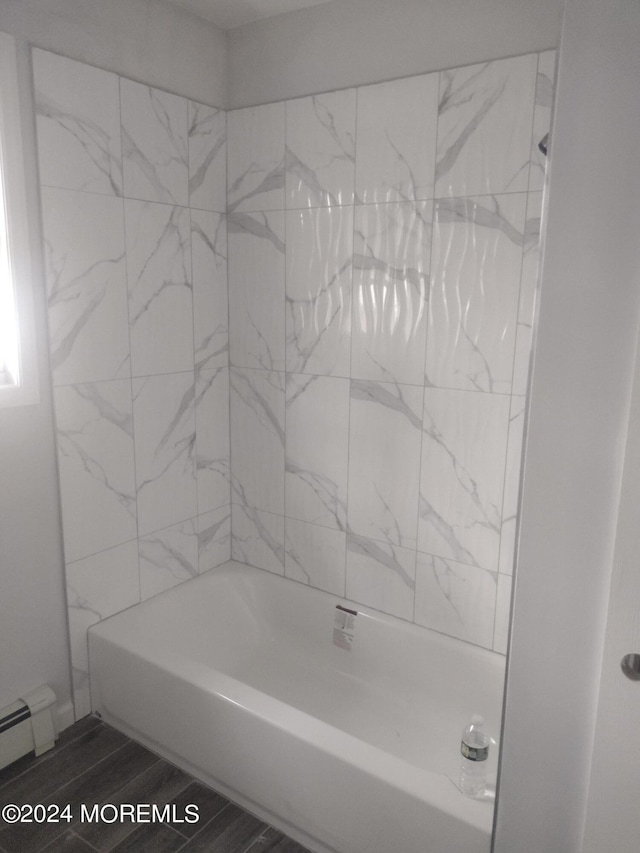 full bathroom with bathtub / shower combination, a baseboard heating unit, and wood finished floors