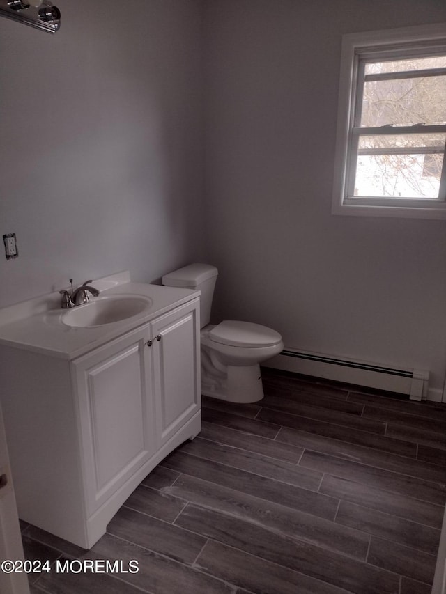 bathroom featuring a baseboard heating unit, toilet, vanity, and wood tiled floor