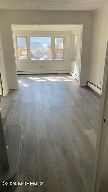 spare room with a baseboard heating unit, a baseboard radiator, and wood finished floors