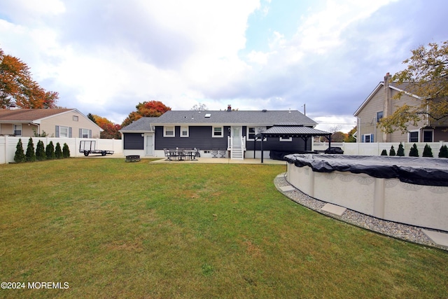 back of house with a gazebo, a patio area, a lawn, and a covered pool