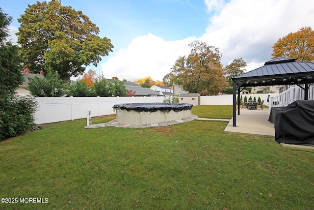 view of yard featuring a covered pool and a gazebo