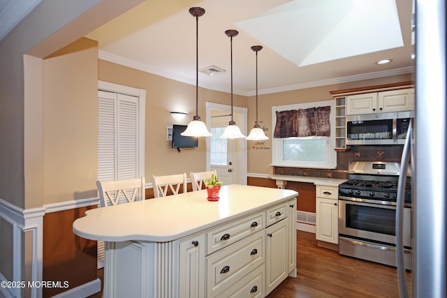 kitchen featuring stainless steel appliances, a center island, a kitchen bar, and hanging light fixtures