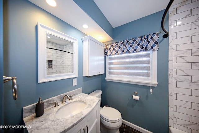 bathroom featuring tiled shower, vanity, and toilet